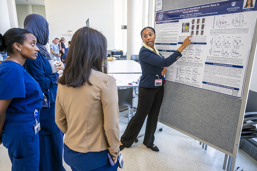 Student explains her research to onlookers