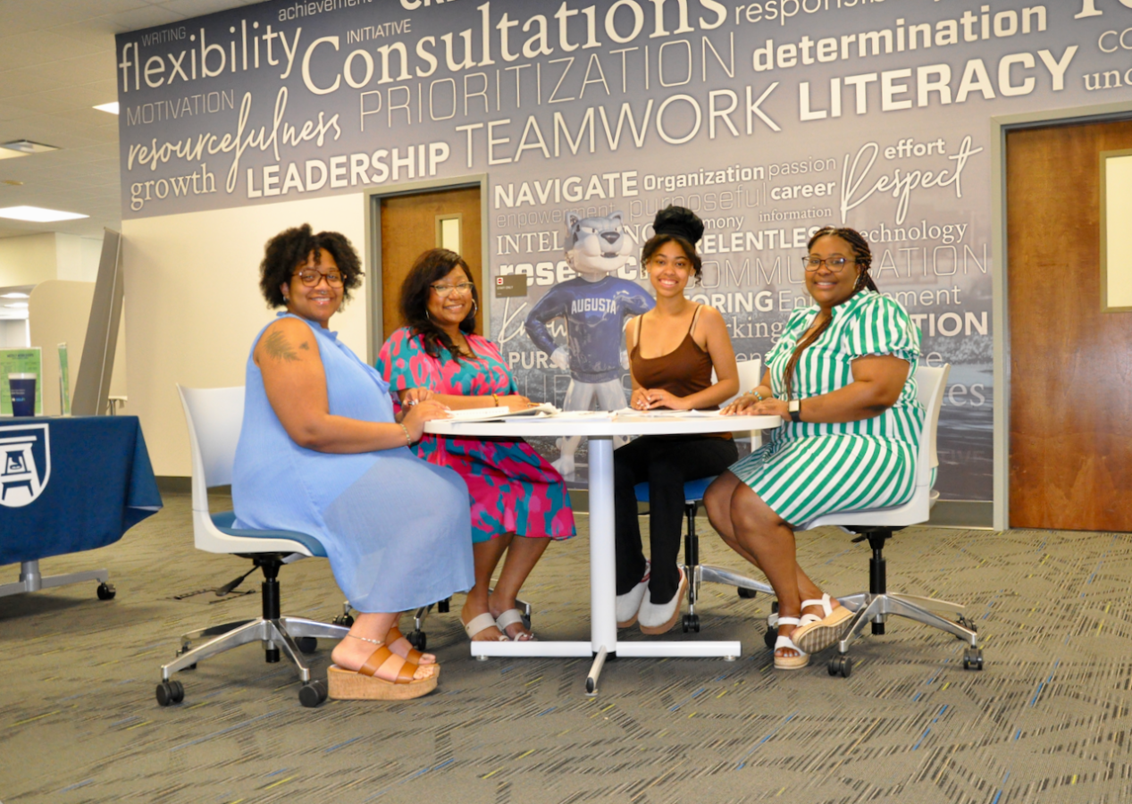 Four women sitting around a table at a meeting