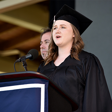 Student singing the alma mater at commencement