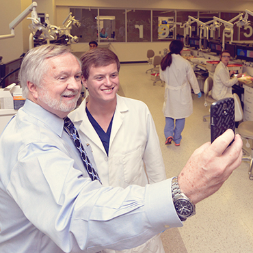 President Keel taking selfi with student.
