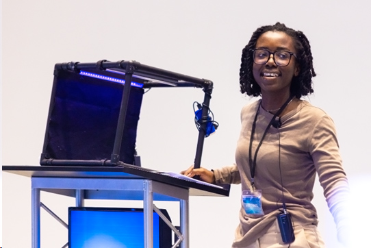 Certificate Of Leadership Women demonstrating her invention in front of audience