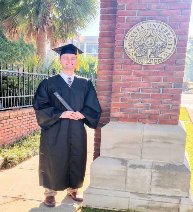 student holding diploma 