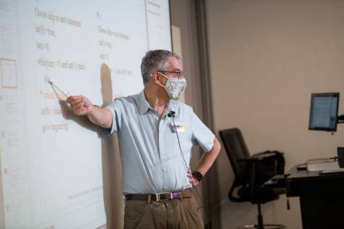 Professor pointing at board 