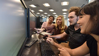 Students working together while looking at computer screens