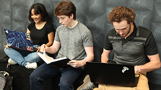 Students sitting and working on laptops