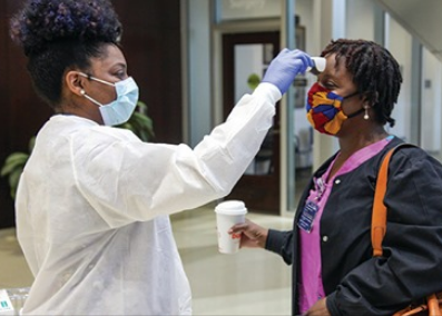 Photo: DCG staff screening patients and employees as they enter the building. 