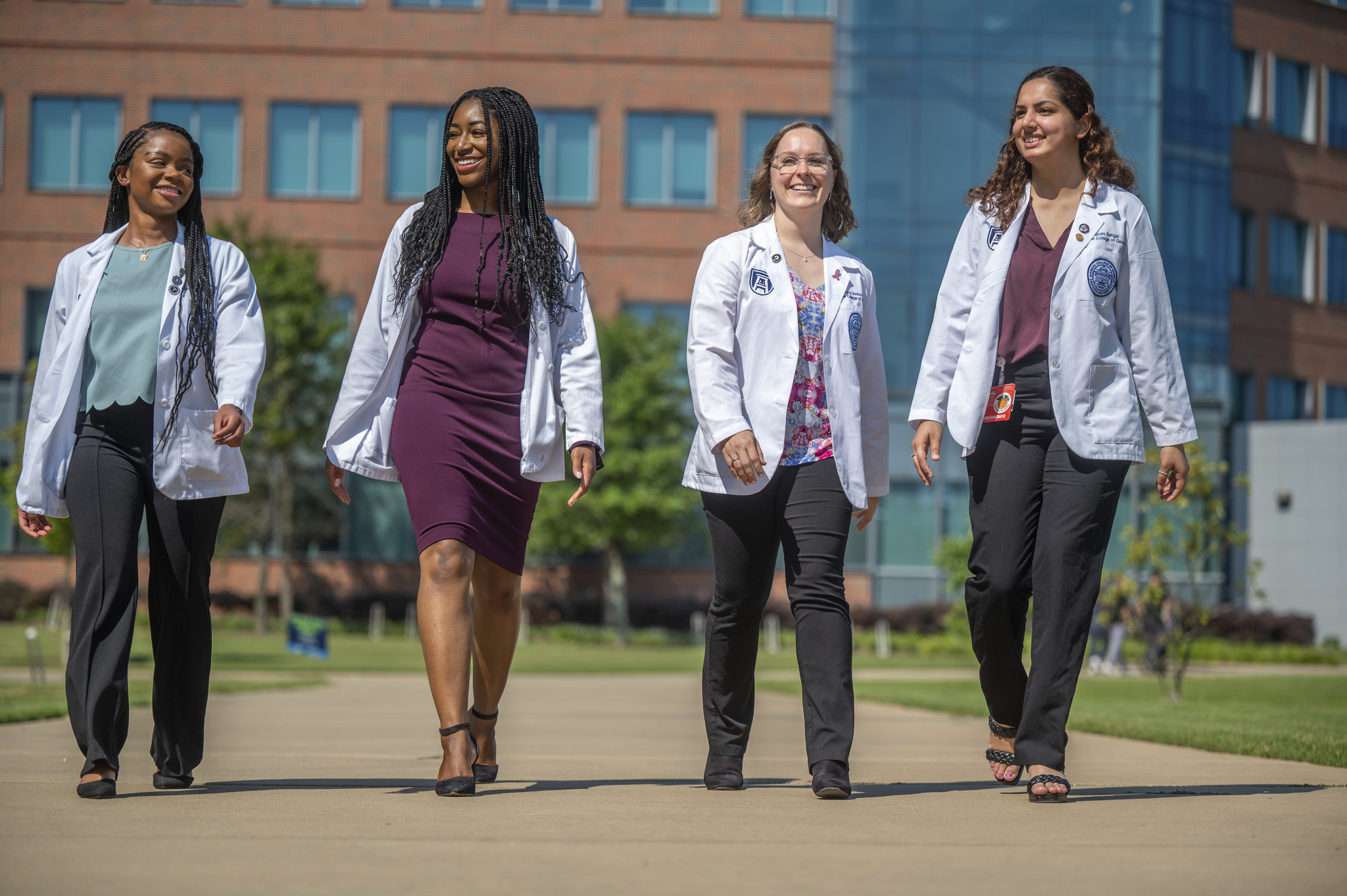 medical students walking ih Harrison Commons building