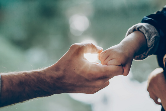 Father holds son's hand