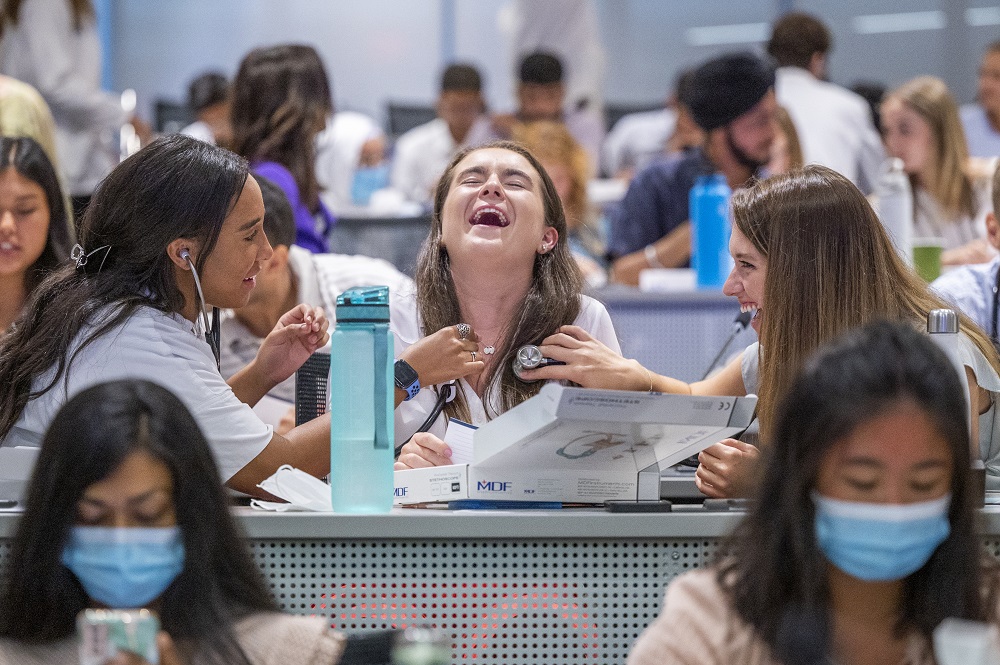 three medical students smile and pose with their new gifted stethoscopes