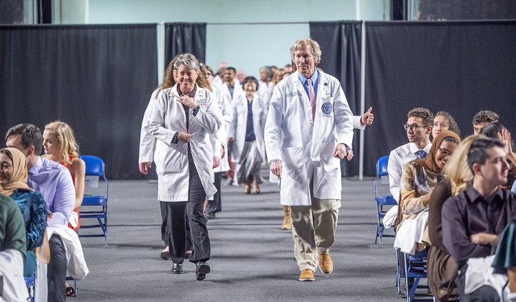 People in white coats walking towards camera