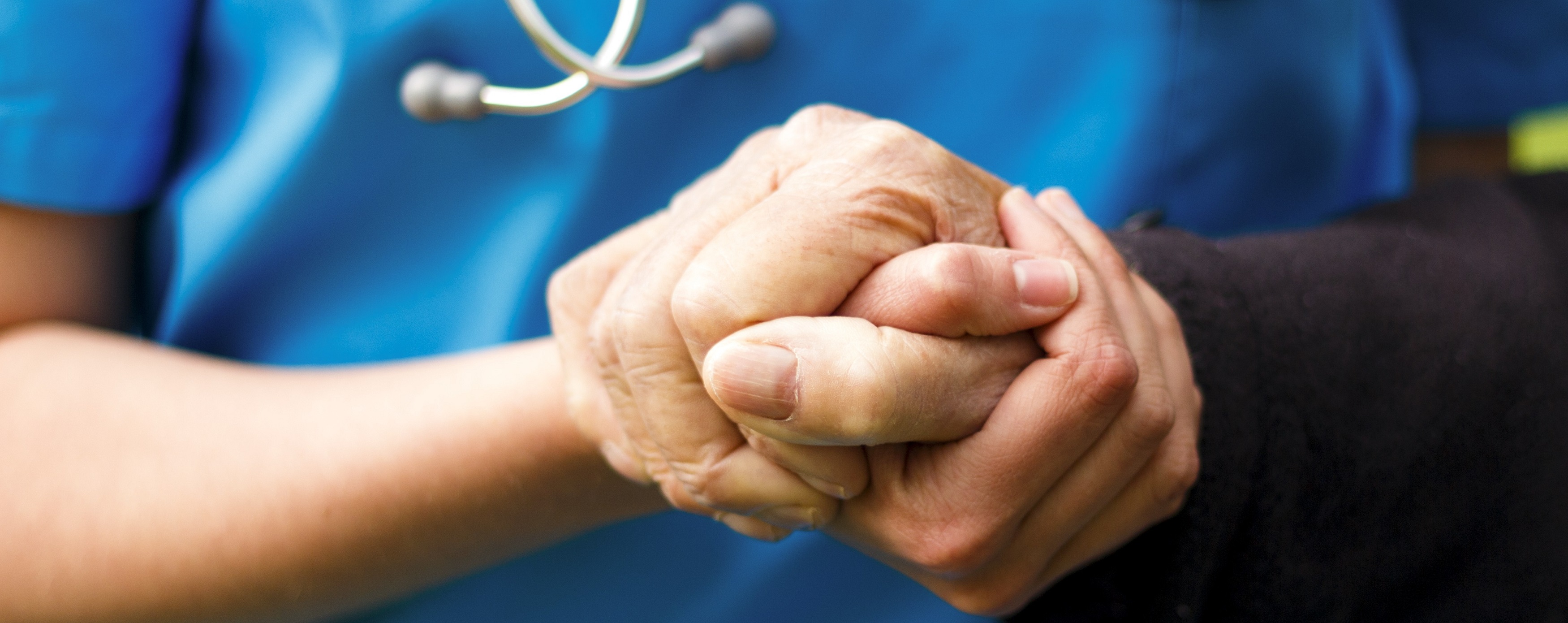 Nurse holding patients hand giving support