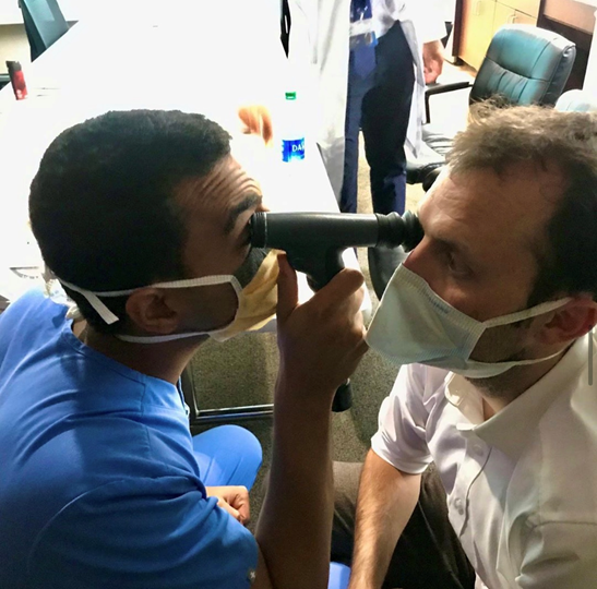 Resident giving eye exam