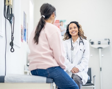 woman facing and speaking with female doctor