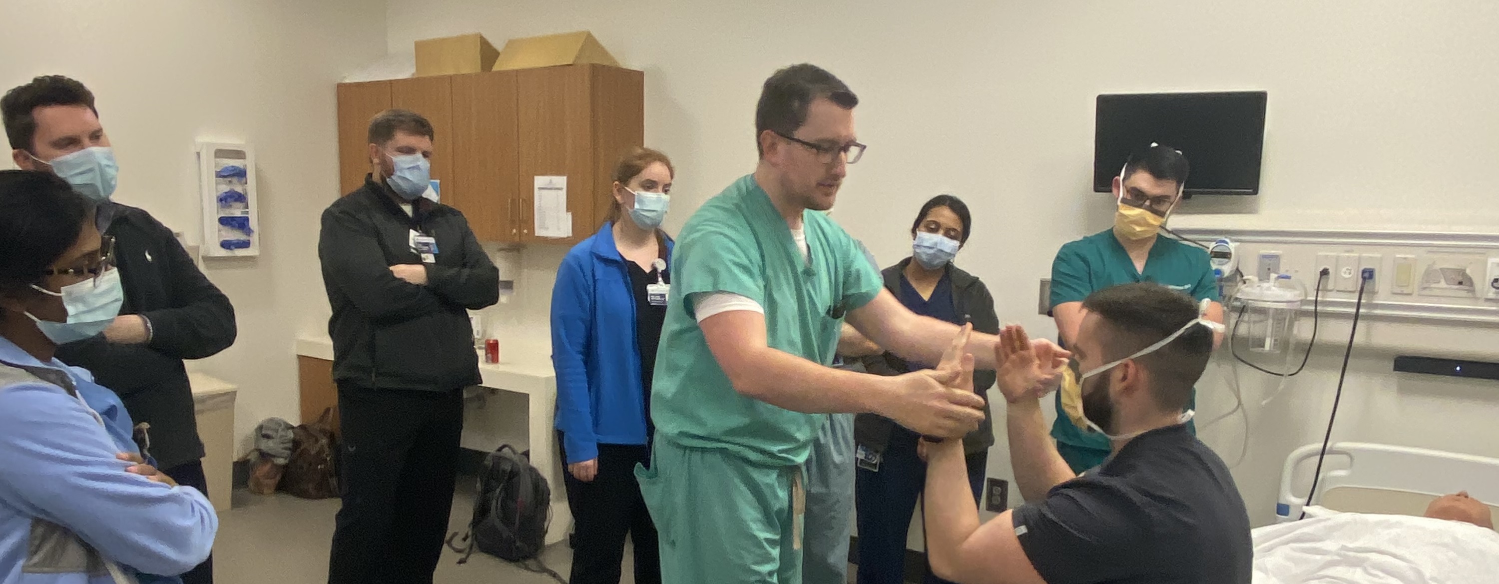 people with medical masks stand around patient