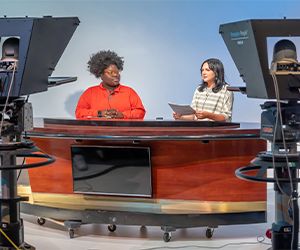 two students at a news table