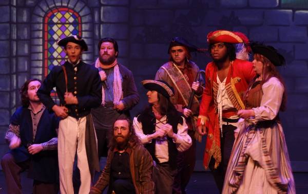 Performance on stage with characters at tables