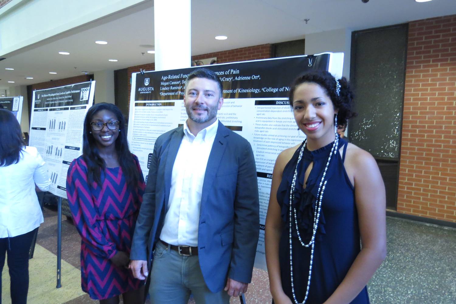 Dr. Laurence Miller and students presenting poster at the 2016 Summer Symposium