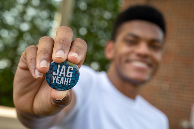 people holding button that says jag yeah