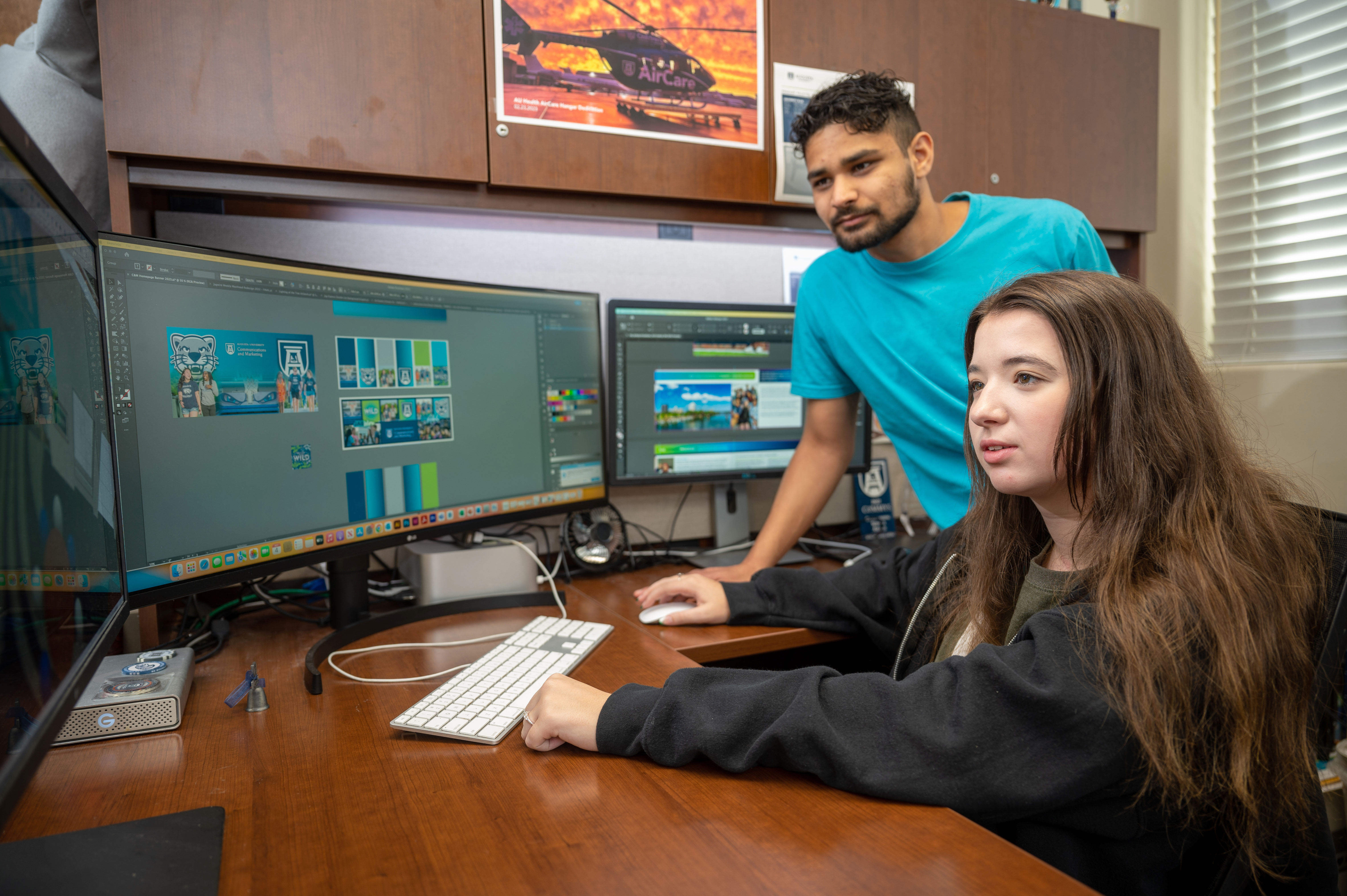 two students looking at computer screen with graphics