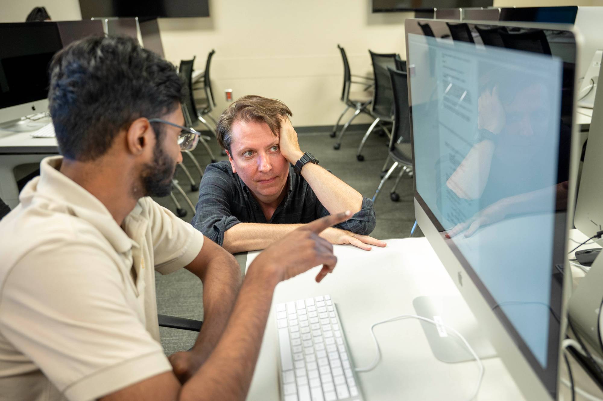 two men looking at computer