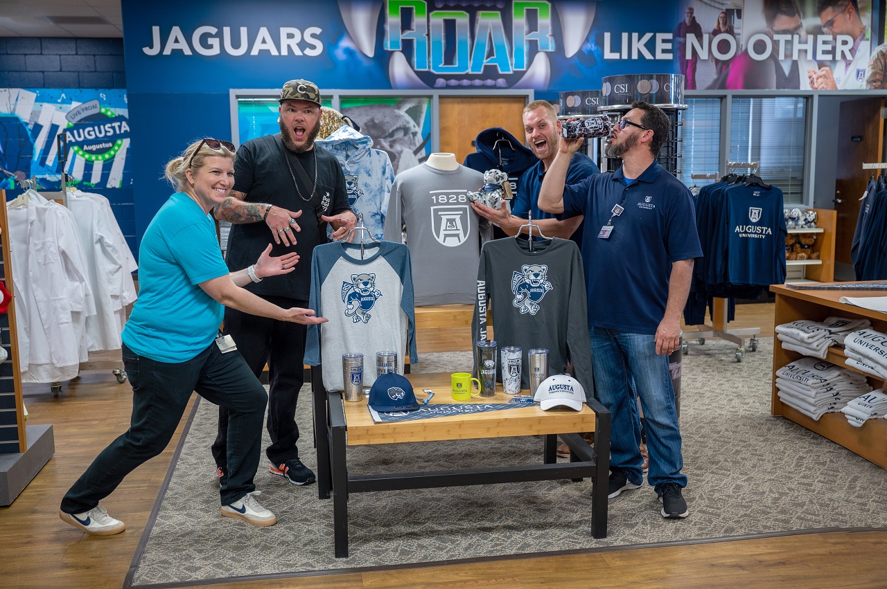 people standing in a clothing store with a sign behind them that says jaguars roar like no other