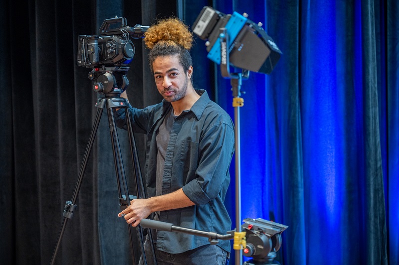 man smiling holding camera
