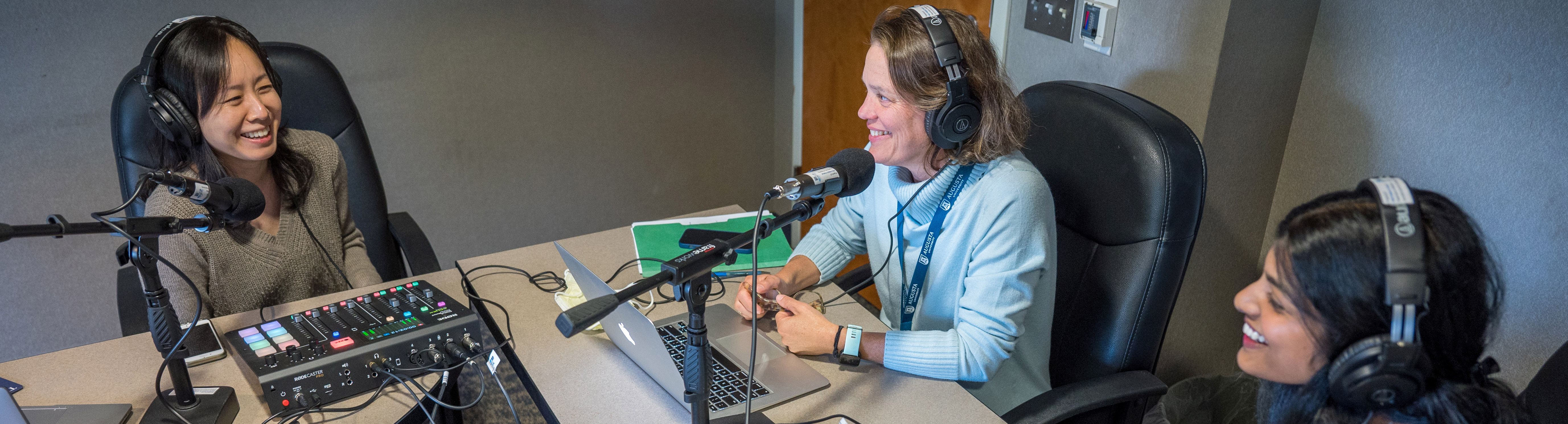 woman smiling in front of podcast mic