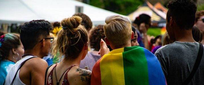 Students attending Lambda Alliance event - one student shrouded in LGBT pride flag