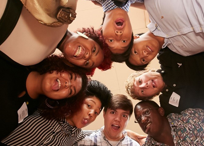 First year students gather together in a circle, looking down at the camera.