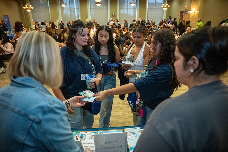 group of students standing in front of a table