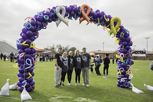 people under a balloon arch