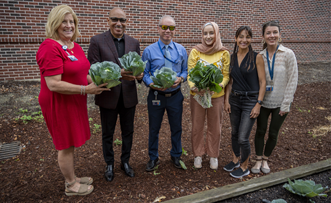 Group of people holding vegtables 