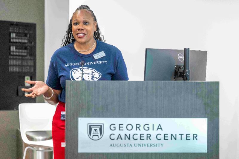 A Graduate Ambassador presents at a podium in the Georgia Cancer Center at Augusta University