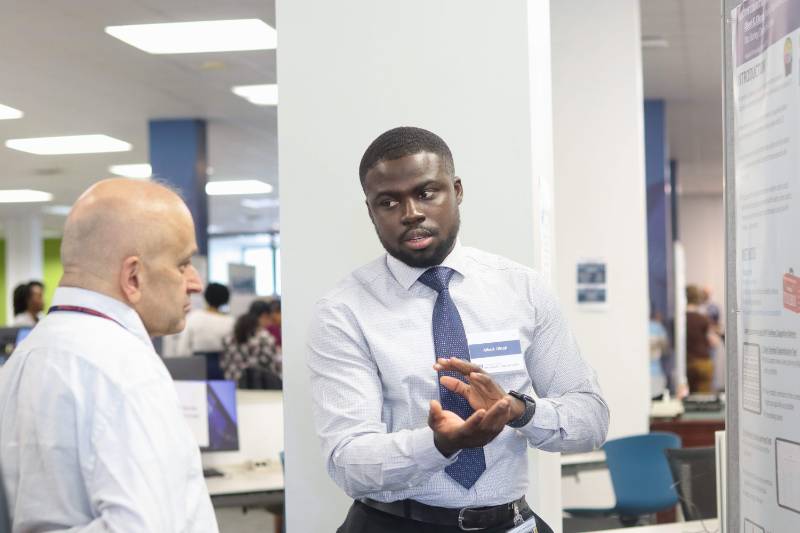 A student presents a research poster at an event