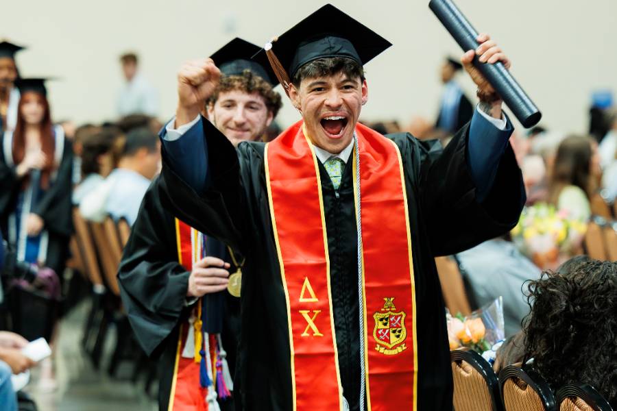 Excited graduate holding diploma tube
