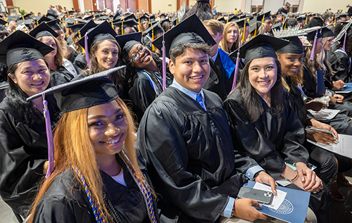 Graduates smiling at Commencement