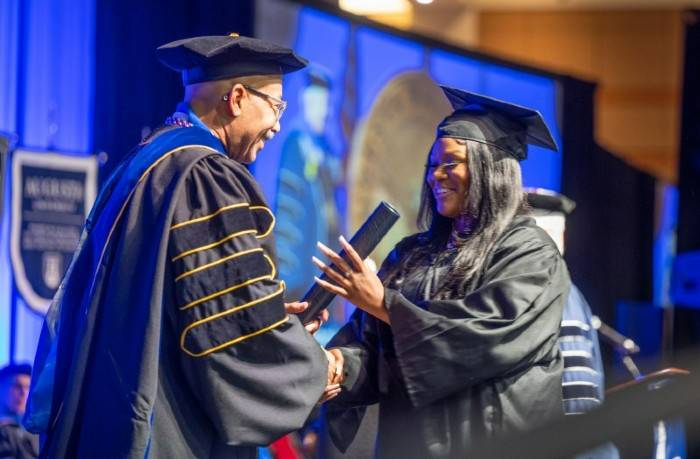 man giving student diploma 