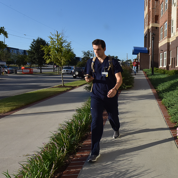 Male student walking hurriedly to class