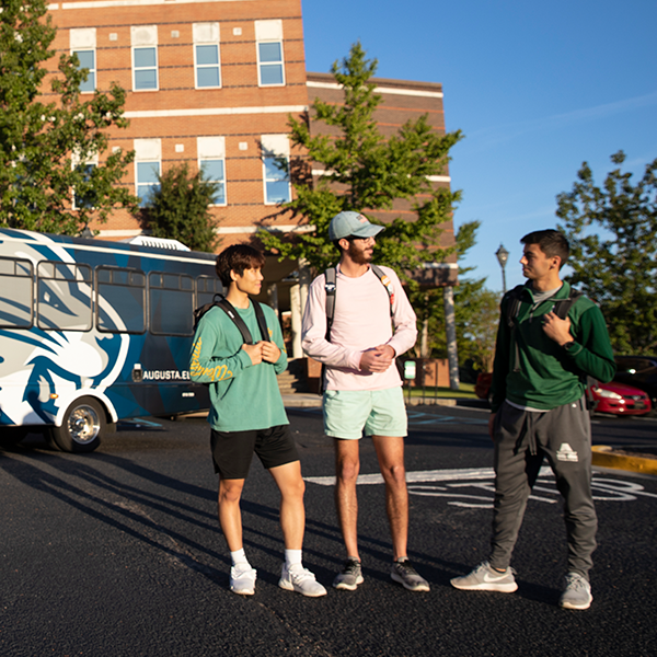 Male students talking in a parking lot on the Summerville Campus