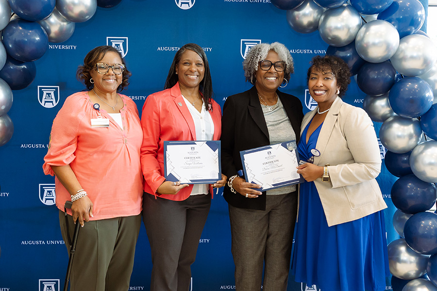 AU employees posing for picture at ceremony