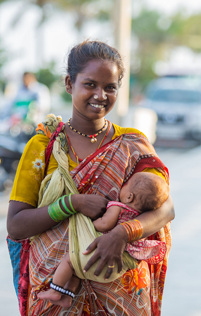 Mother smiling at camera feeding her baby