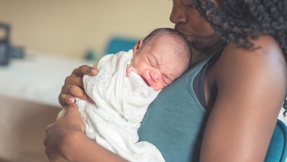 Mother comforting crying newborn