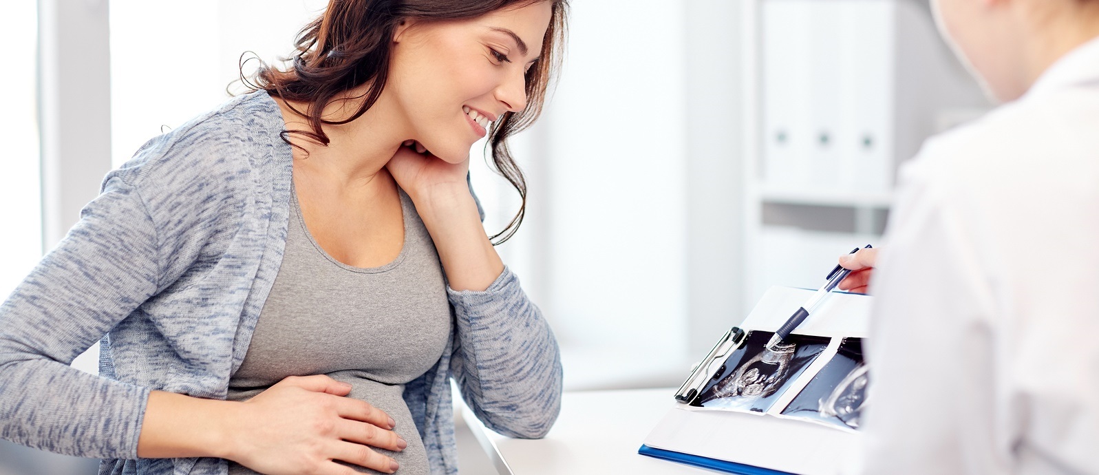 Pregnant woman at doctor's looking at ultrasound