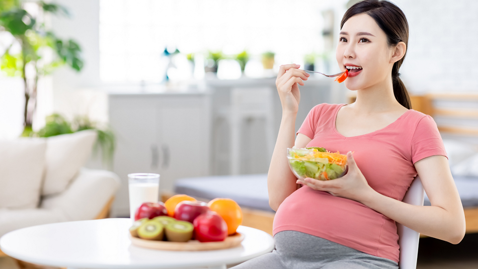 Woman eating a salad sitting at a table