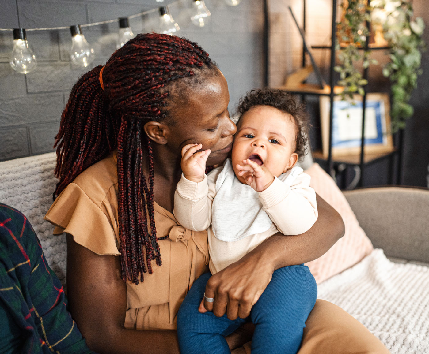 woman snuggles adorable curly-haired baby