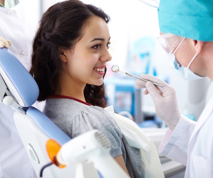 woman listens to dentist talkin to her