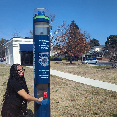 Student presses emergency button on campus emergency phone tower.