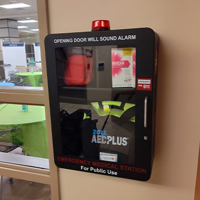A Safe Cabinet mounted in the hallway of a classroom buildling.
