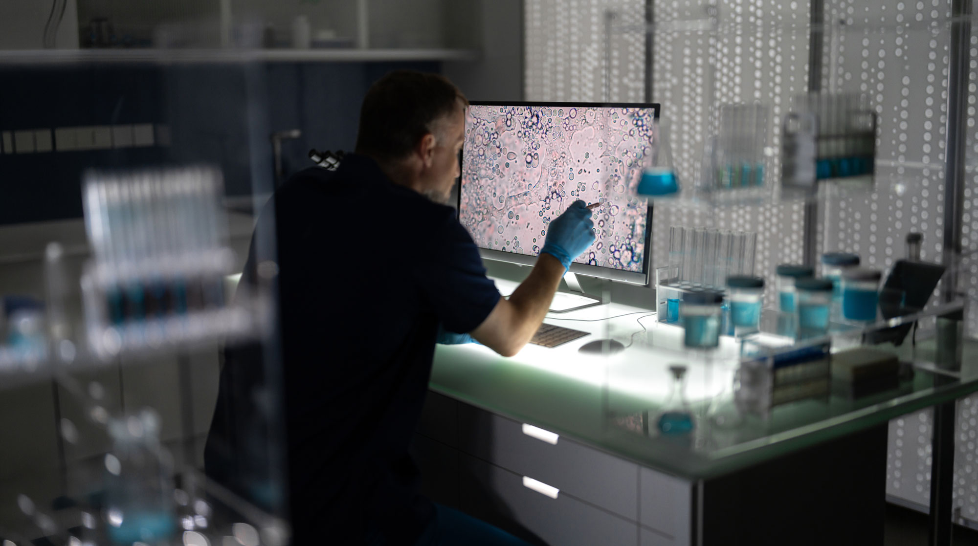 Researcher studies information on a screen in a lab.