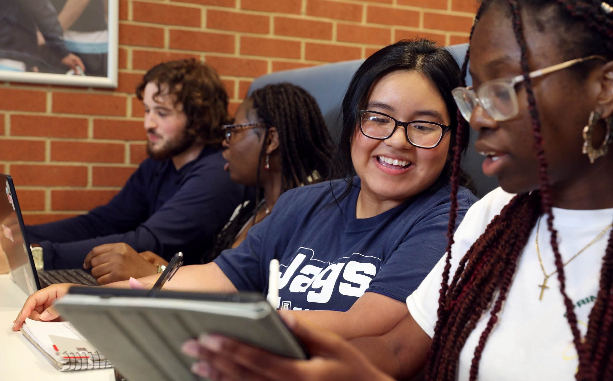 Augusta University students work together with laptops and a tablet.